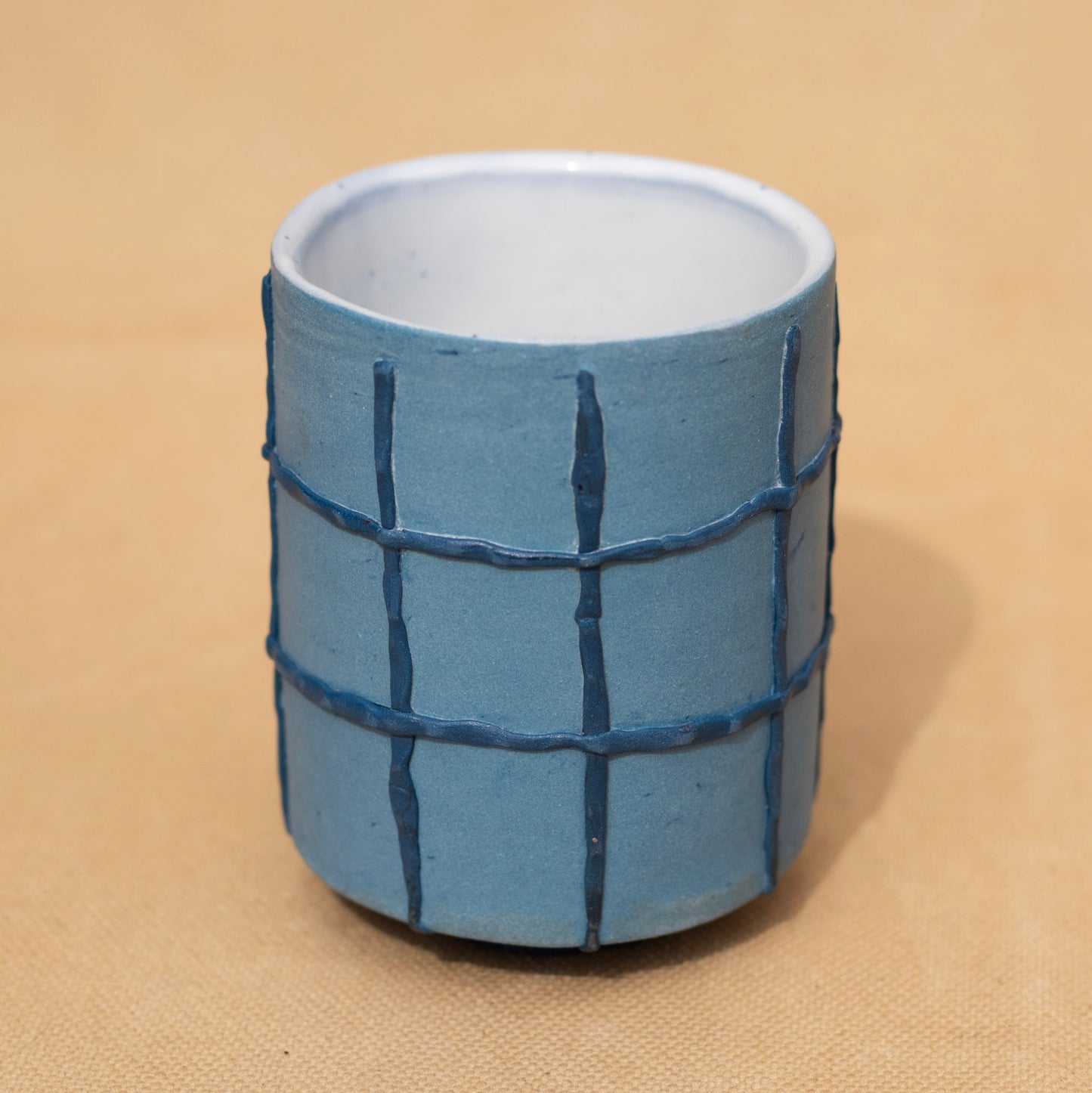 Handmade blue cup with a dark blue grid