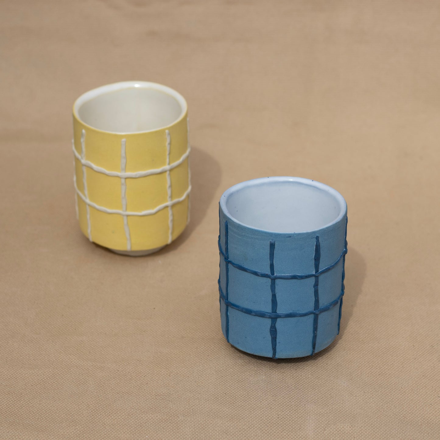 Two handmade cups with a grid decoration