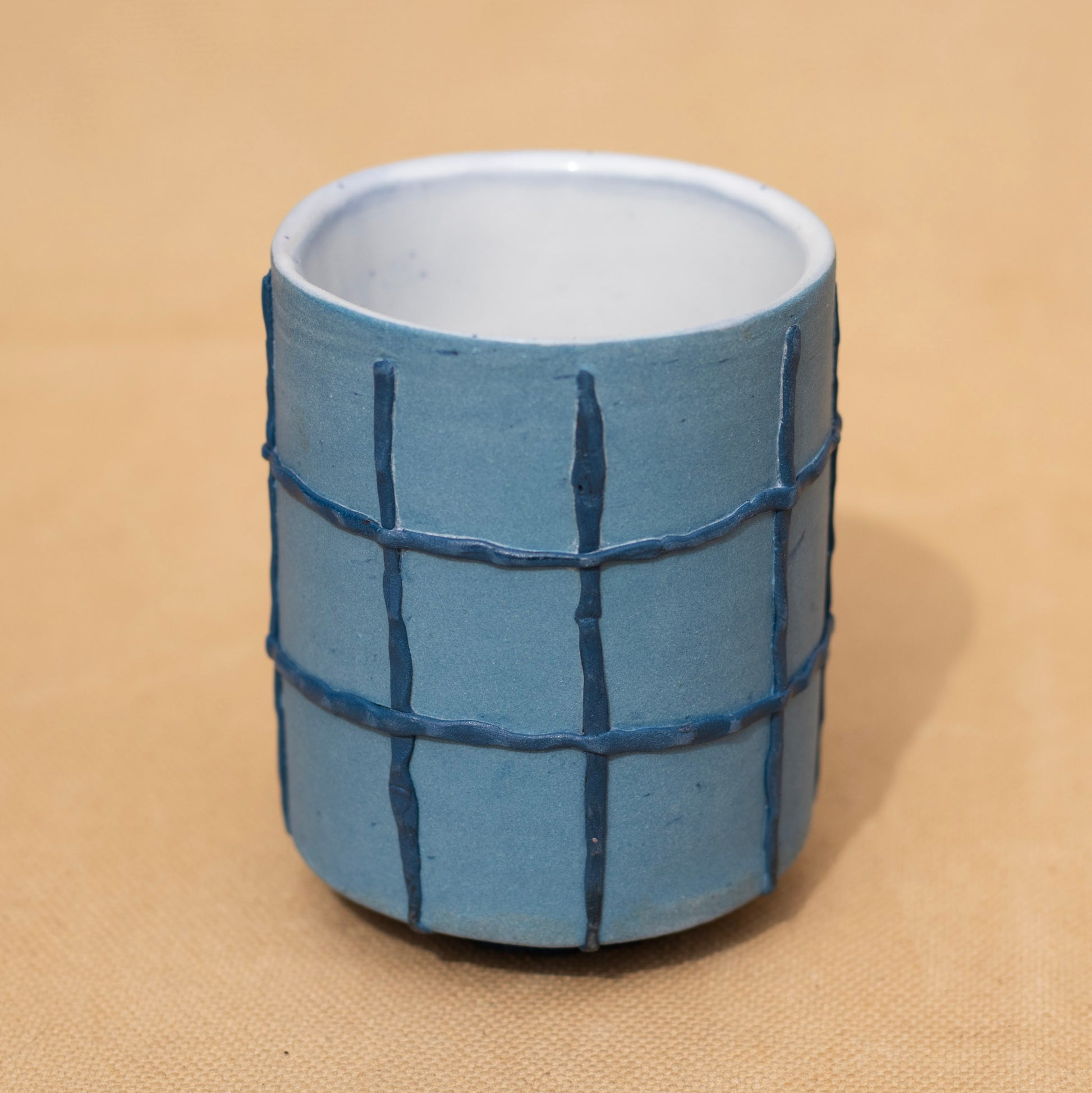 Handmade blue cup with a dark blue grid